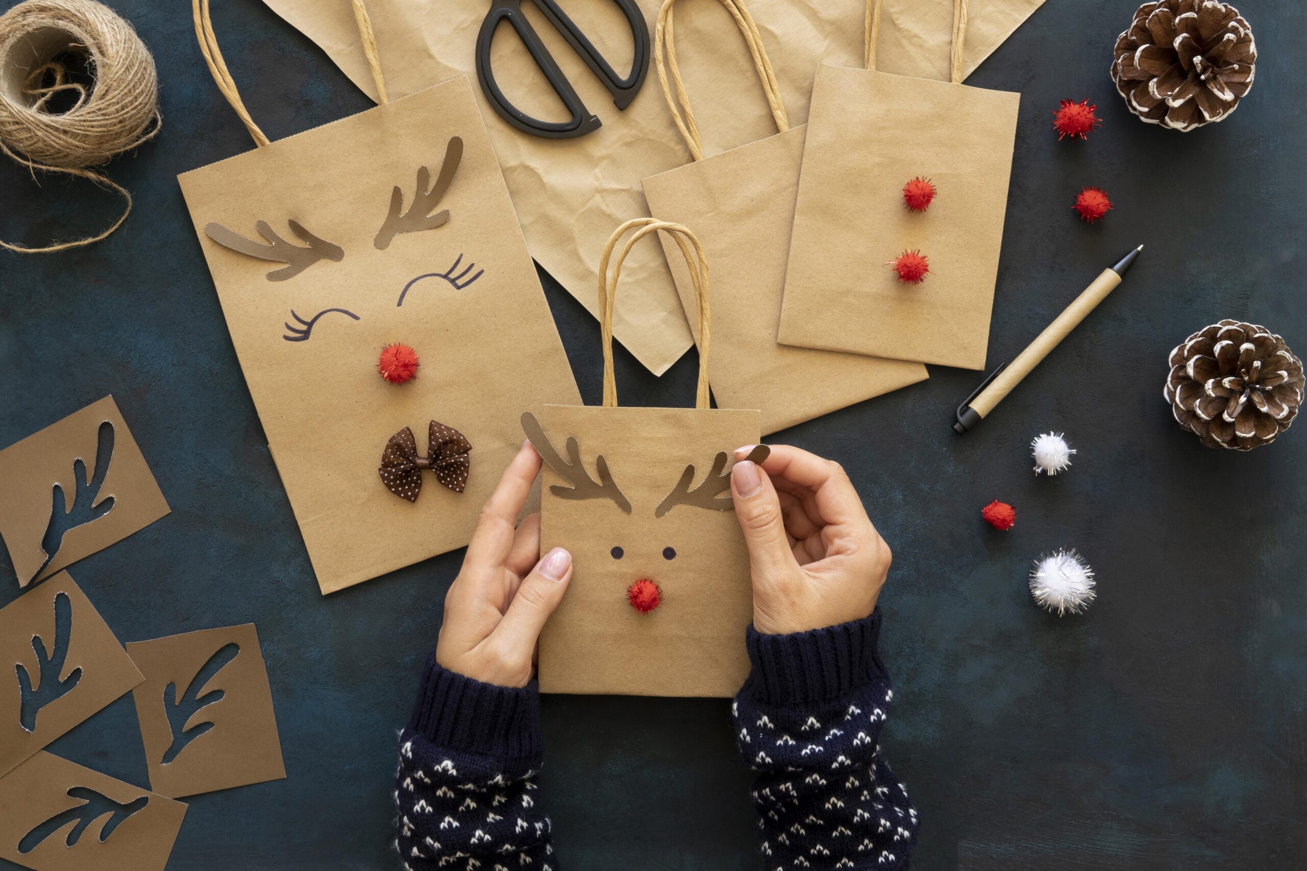 hands decorating christmas paper bags